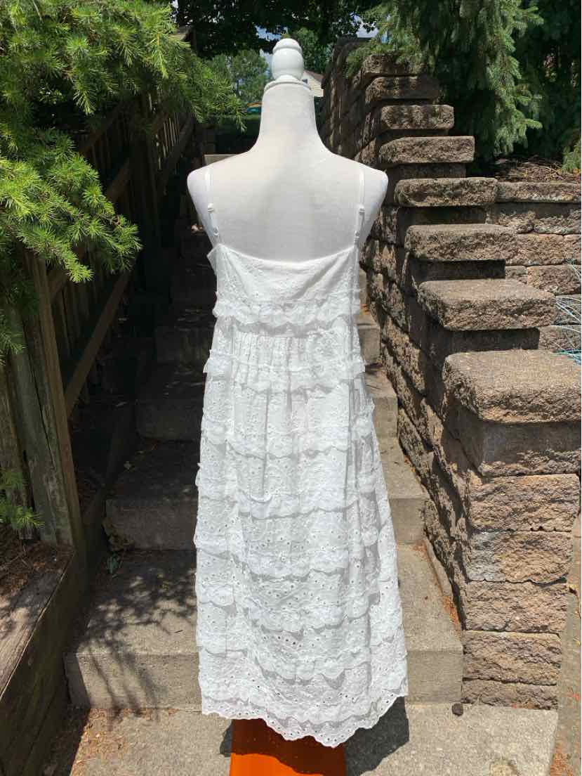 White eyelet lace sundress with tiered ruffles and spaghetti straps on mannequin, back view.
