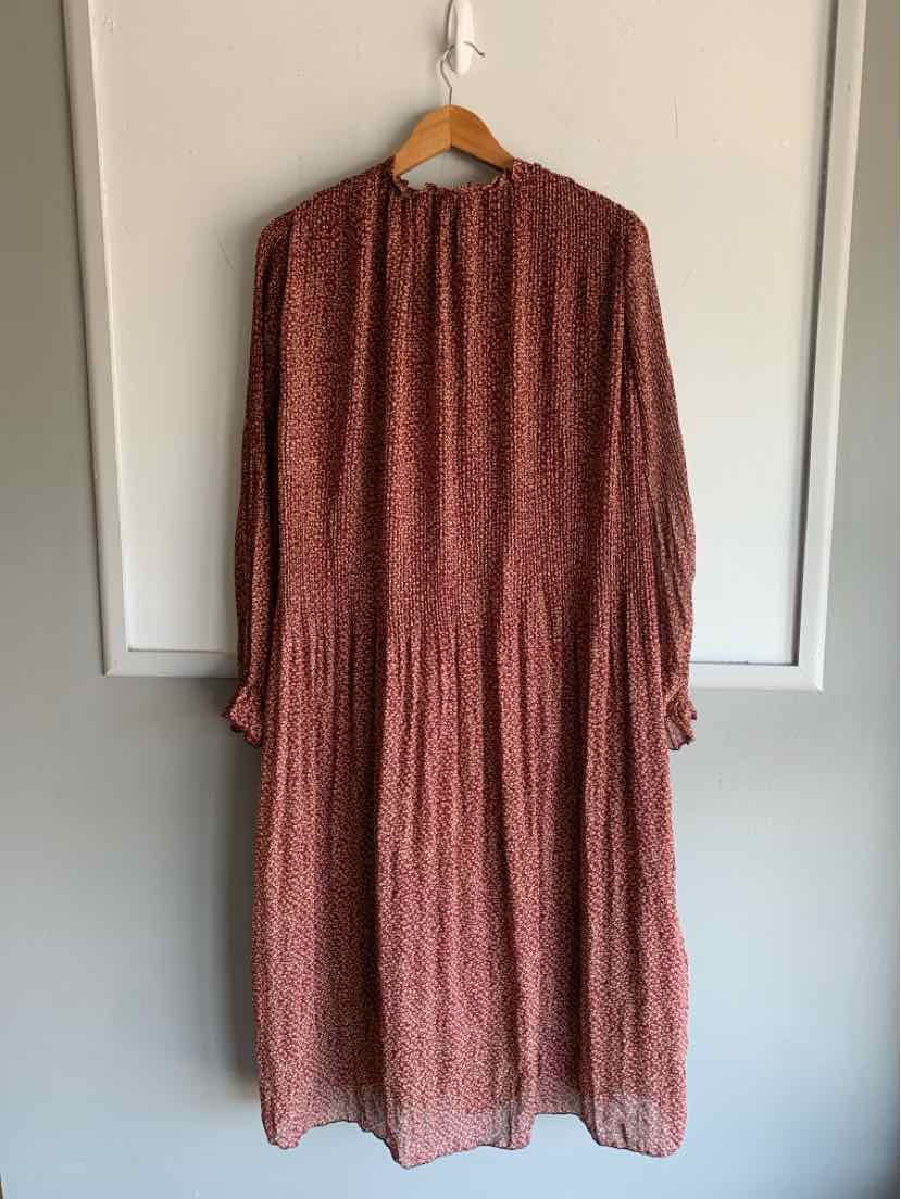 Long-sleeve burgundy midi dress with small floral print and gathered waist hanging on wooden hanger.