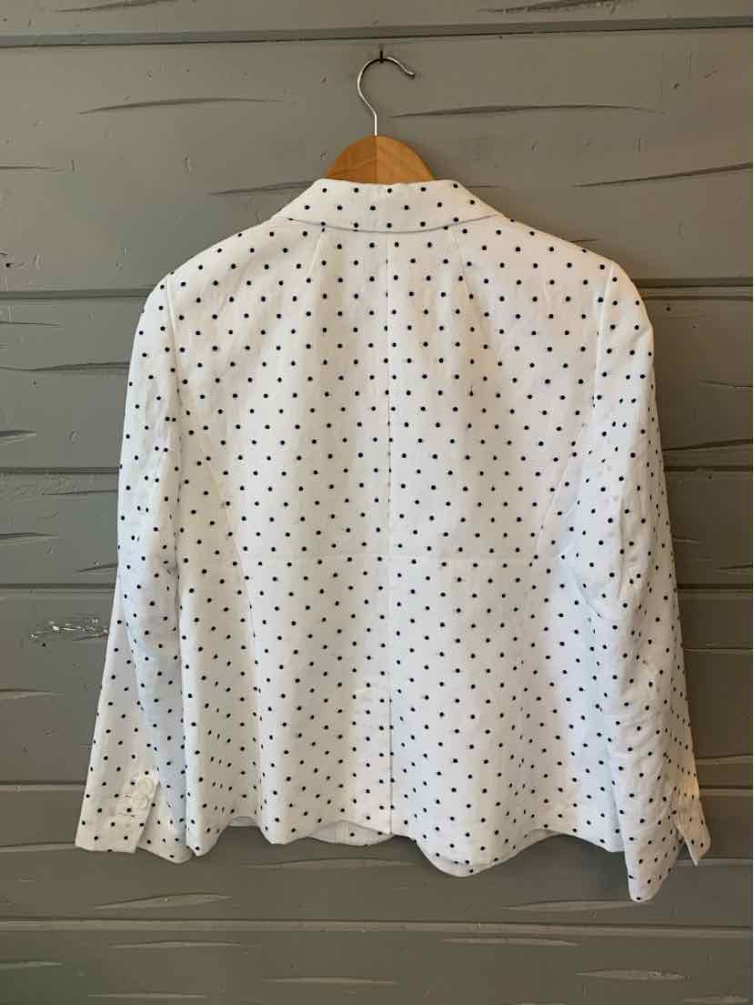 White button-up blouse with black polka dots, long sleeves, and classic collar.