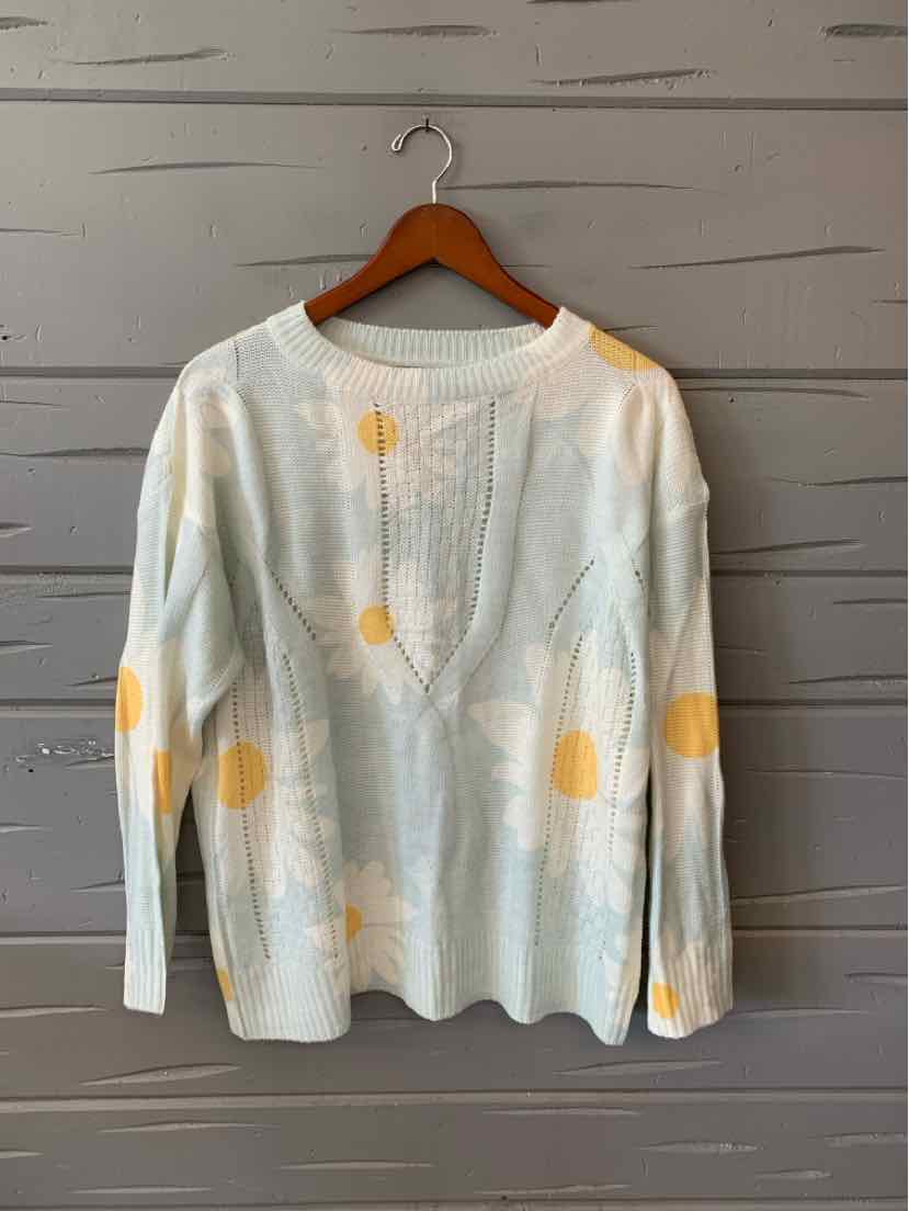 White long-sleeve sweater with yellow floral print and textured fabric detailing.