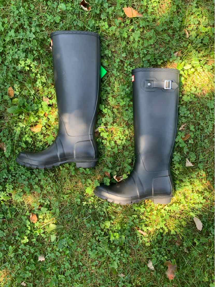 Black tall rubber boots with adjustable buckle strap and rounded toes, size 8.