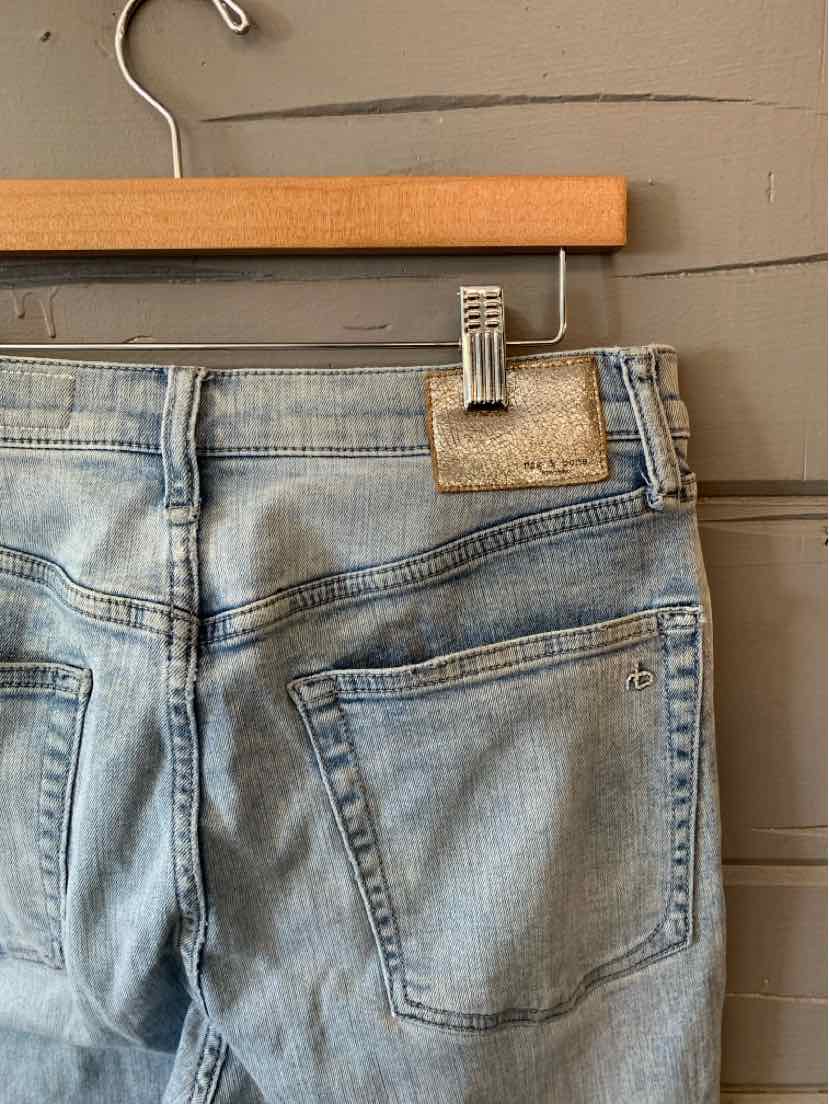 Light blue faded denim jeans with back pockets and a leather brand patch on the waistband.