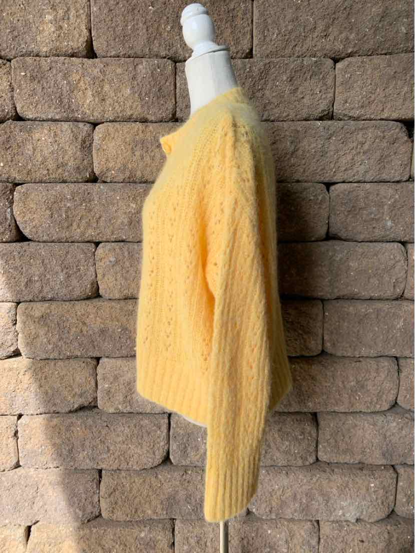 Mustard yellow fuzzy knit sweater with a loose fit and long sleeves, displayed on a mannequin.