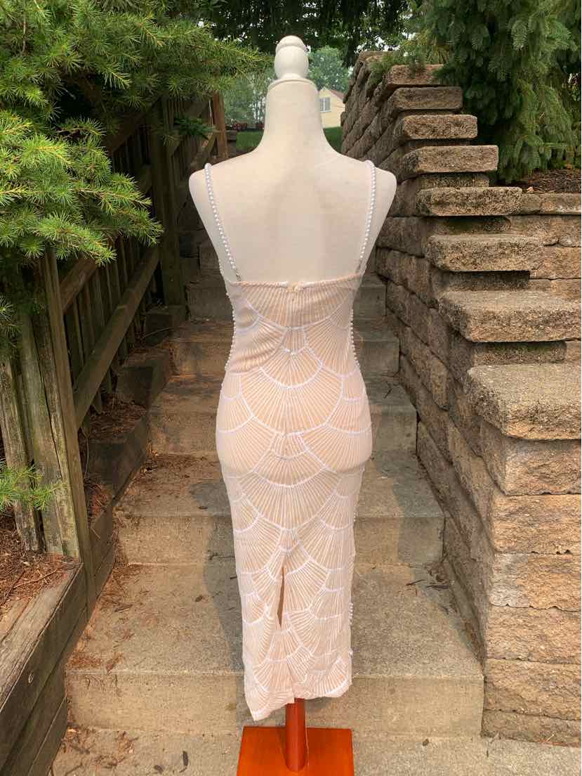Tan midi slip dress with thin straps, sheer lace fabric, and floral pattern, fitted silhouette.