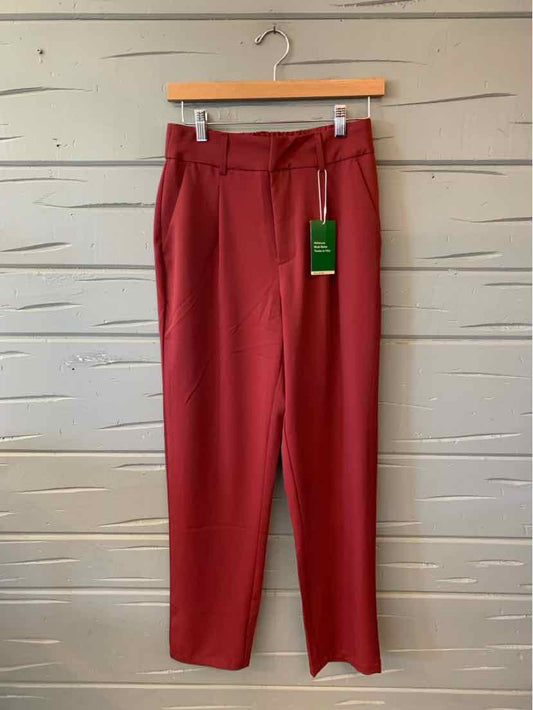 Solid red straight-leg trousers with a flat front, belt loops, and a green hang tag.