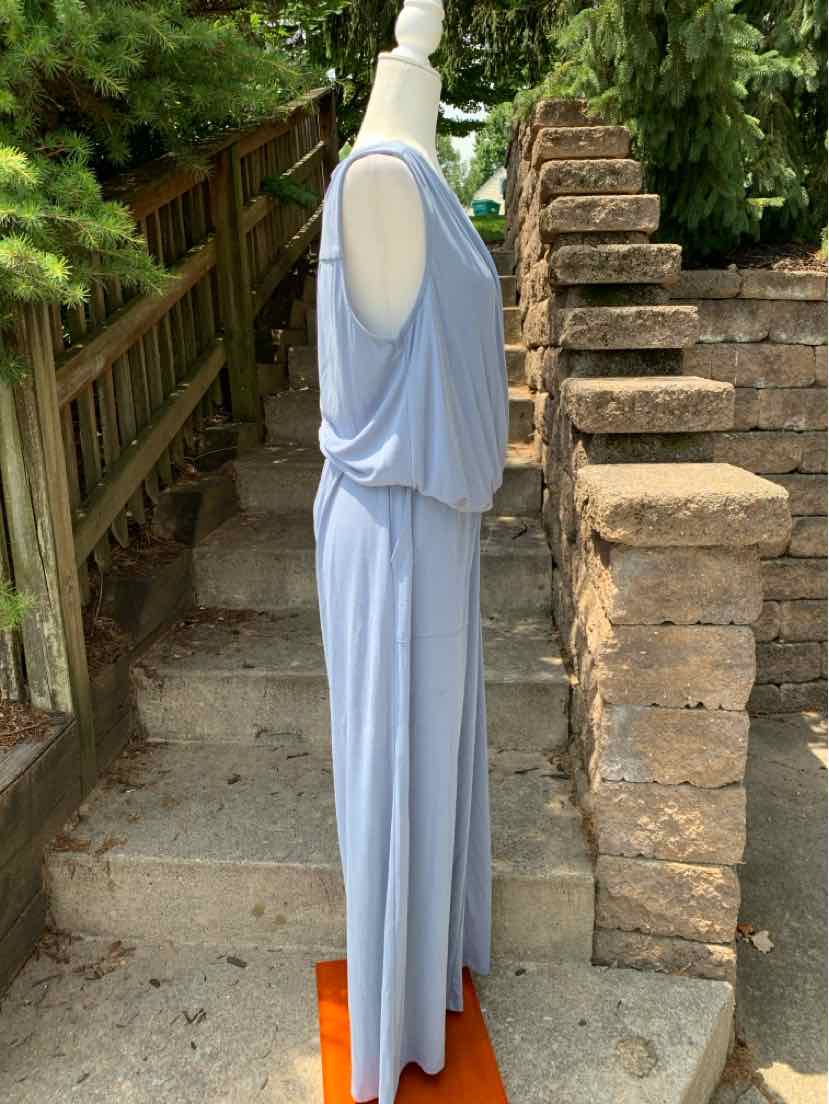 Light blue sleeveless romper with draped bodice and wide-leg pants displayed on mannequin outdoors.