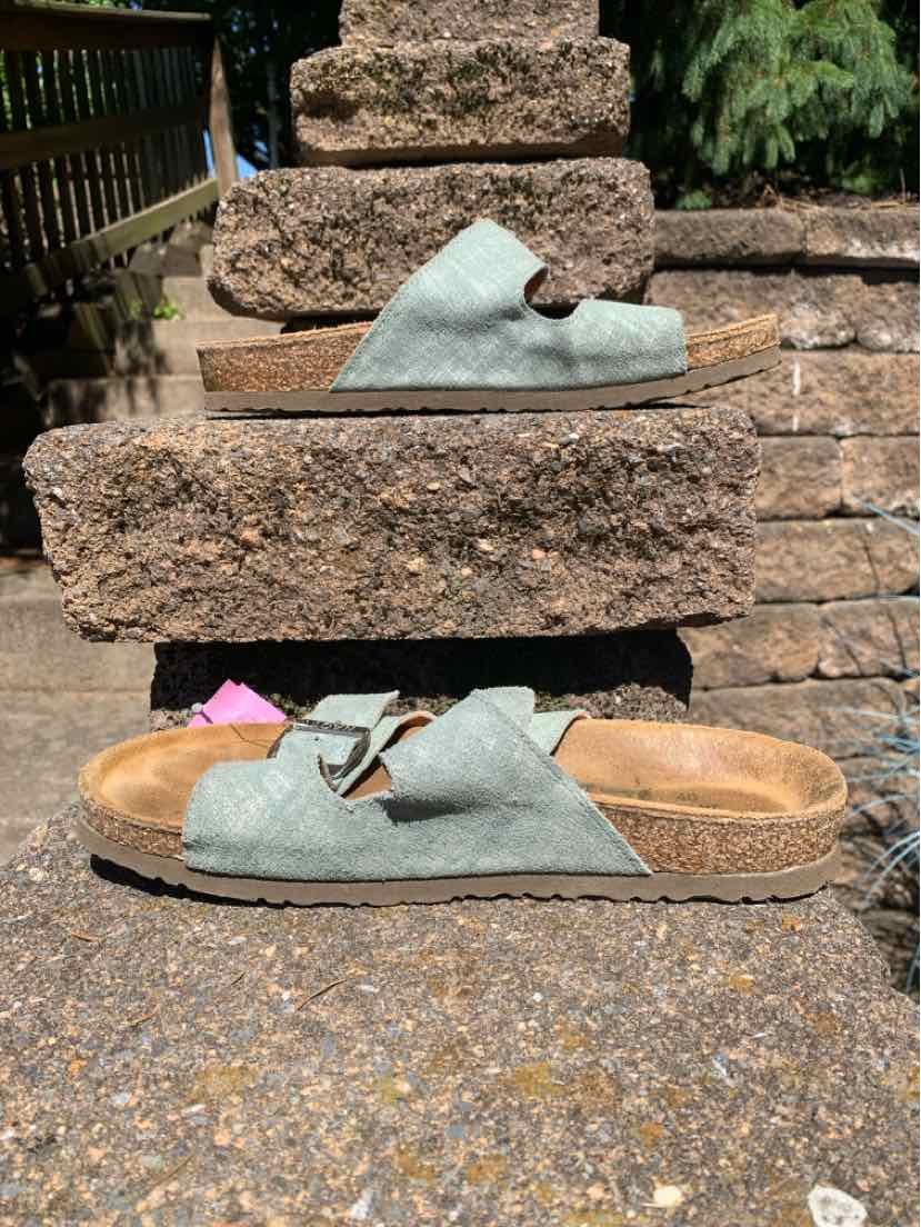 Light blue suede open-toe sandal with adjustable straps and cork footbed.