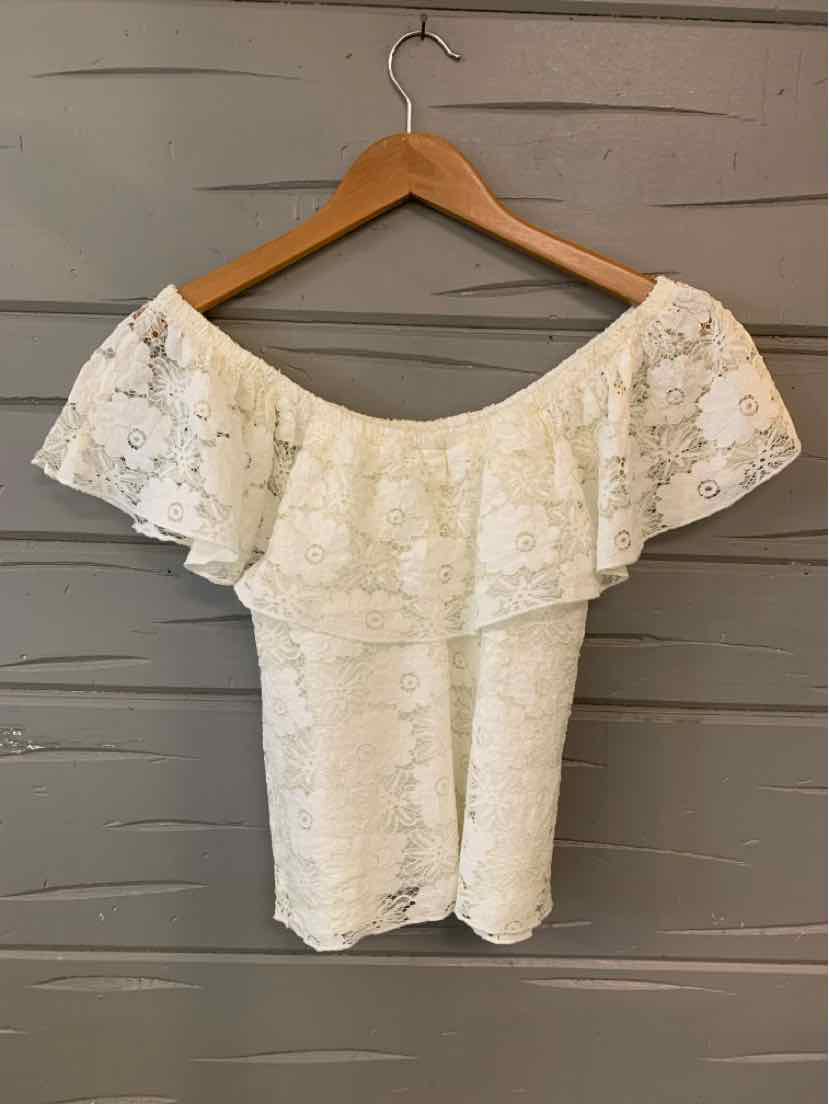 White off-shoulder lace top with ruffled neckline, size small, hanging on wooden hanger.