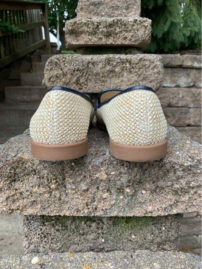 Beige woven slip-on shoes with dark trim and flat tan soles, size 9.5.