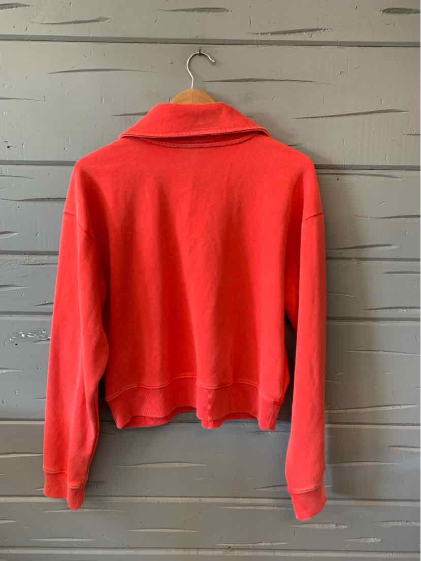 Coral red long-sleeve pullover with a wide collar and cropped hem hanging on a hanger.