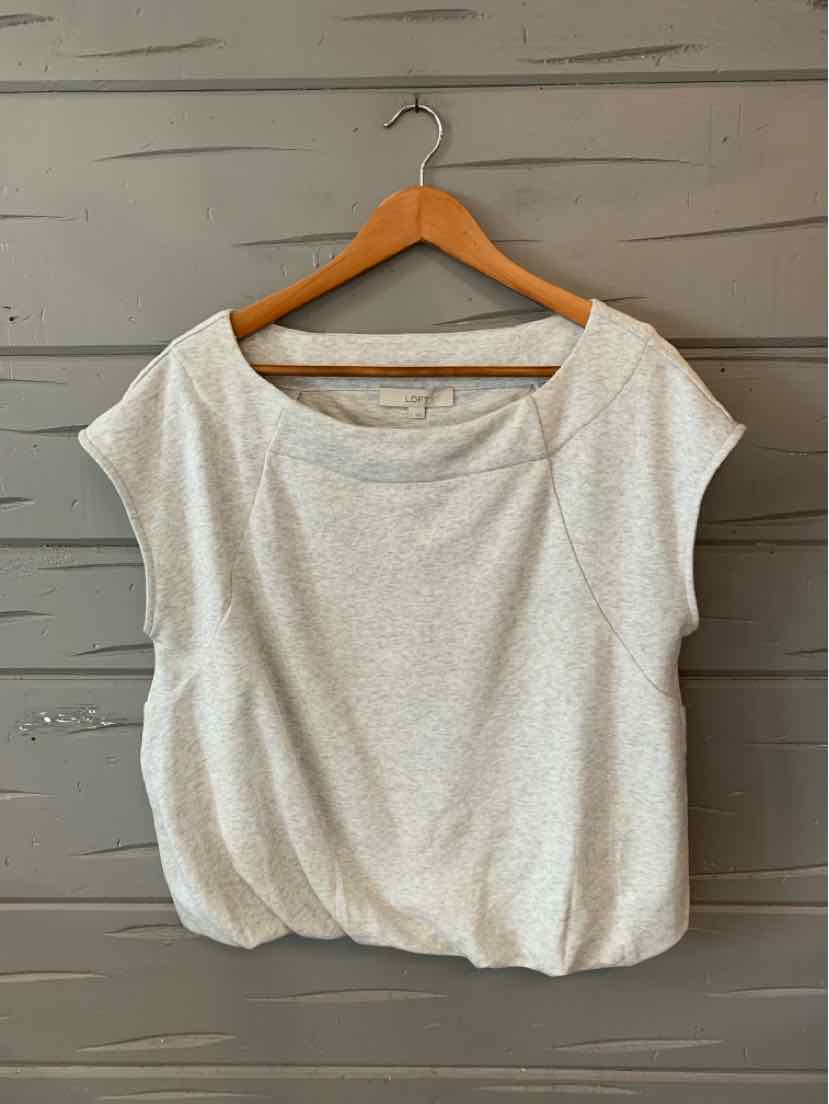 Light gray short-sleeve loose-fit top with wide scoop neckline and gathered hem on wooden hanger.