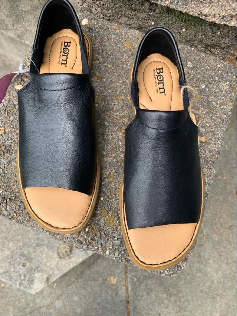 Black leather slip-on sandals with tan cushioned insoles and open toes, size 9.
