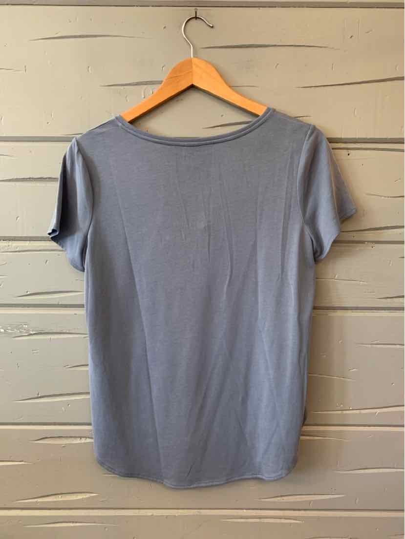 Soft light blue short-sleeve cotton-blend blouse with round neckline and relaxed fit on wooden hanger.