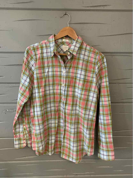 Green and pink plaid long-sleeve button-up shirt hanging on wooden hanger.