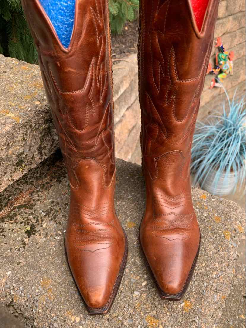 Brown leather Western-style boots with pointed toes and stitched detailing on the shaft.