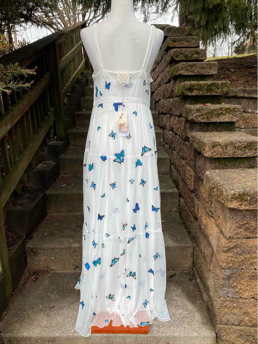 White sleeveless maxi dress with blue butterfly print and adjustable shoulder straps.