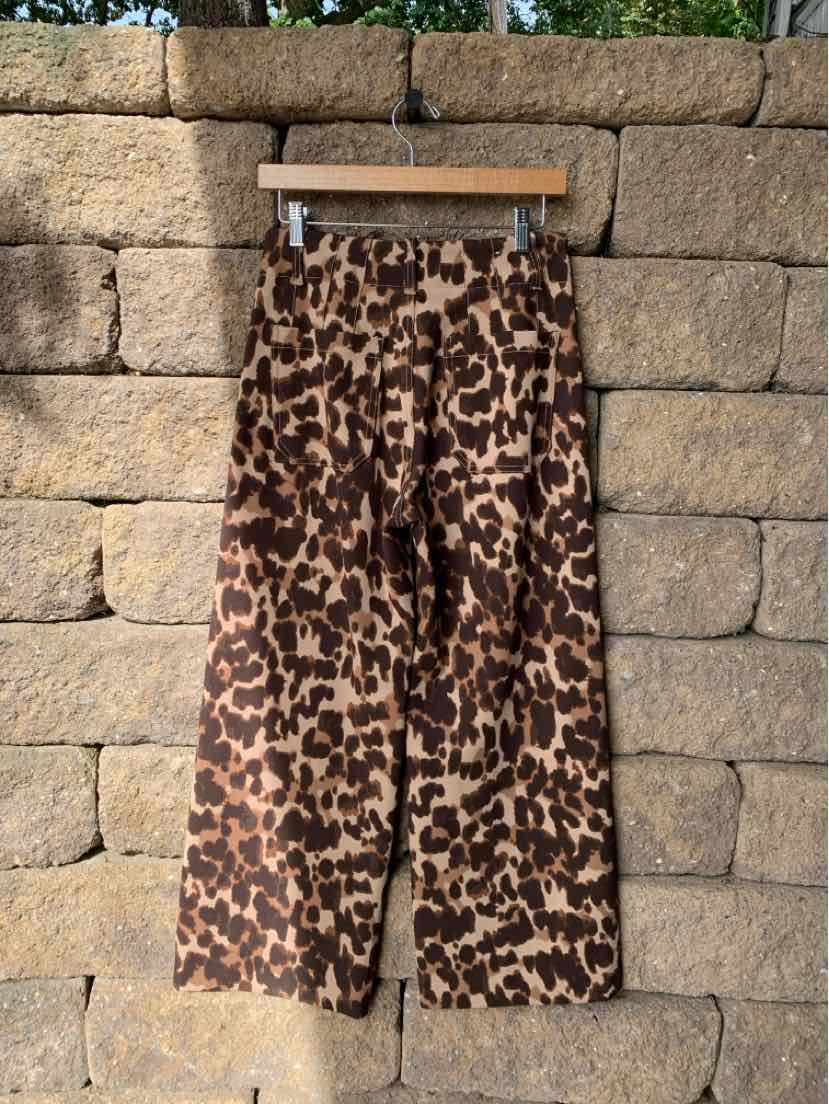 Women’s wide-leg Maeve trousers in brown and black cheetah print, hanging from a wooden clip hanger.