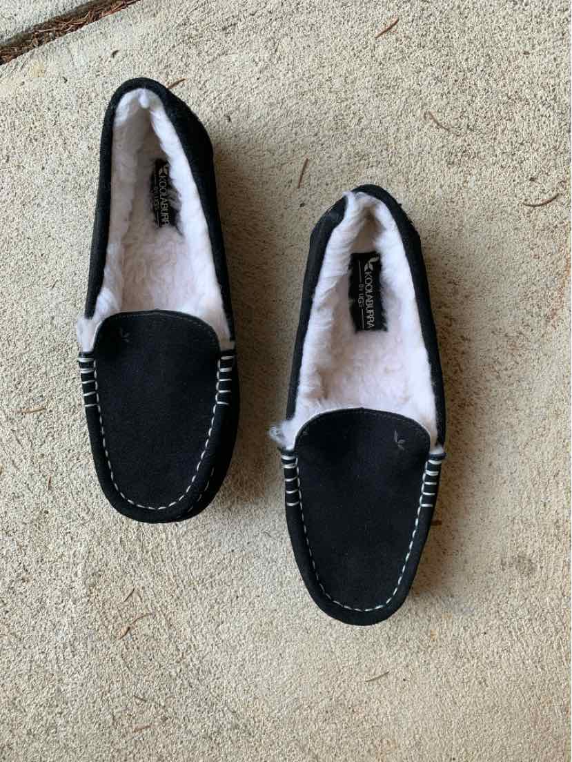 Black suede moccasin slippers with white fleece lining and contrast stitching, size 6.