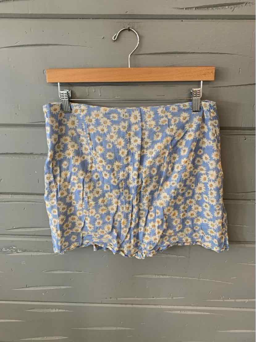 Light blue mini skirt with white and yellow daisy floral print, zipper at side waistband.