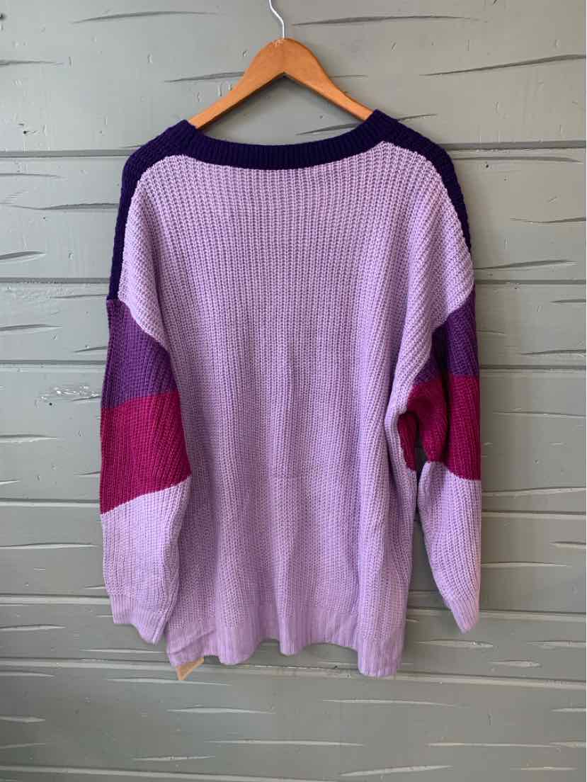Color-blocked oversized sweater in light purple with dark purple and magenta sleeve accents.