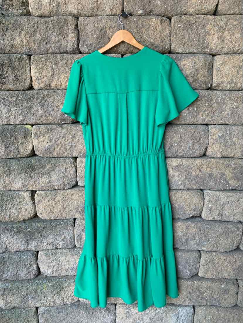 Green midi dress with short flutter sleeves, tiered skirt, and cinched waist on wooden hanger.