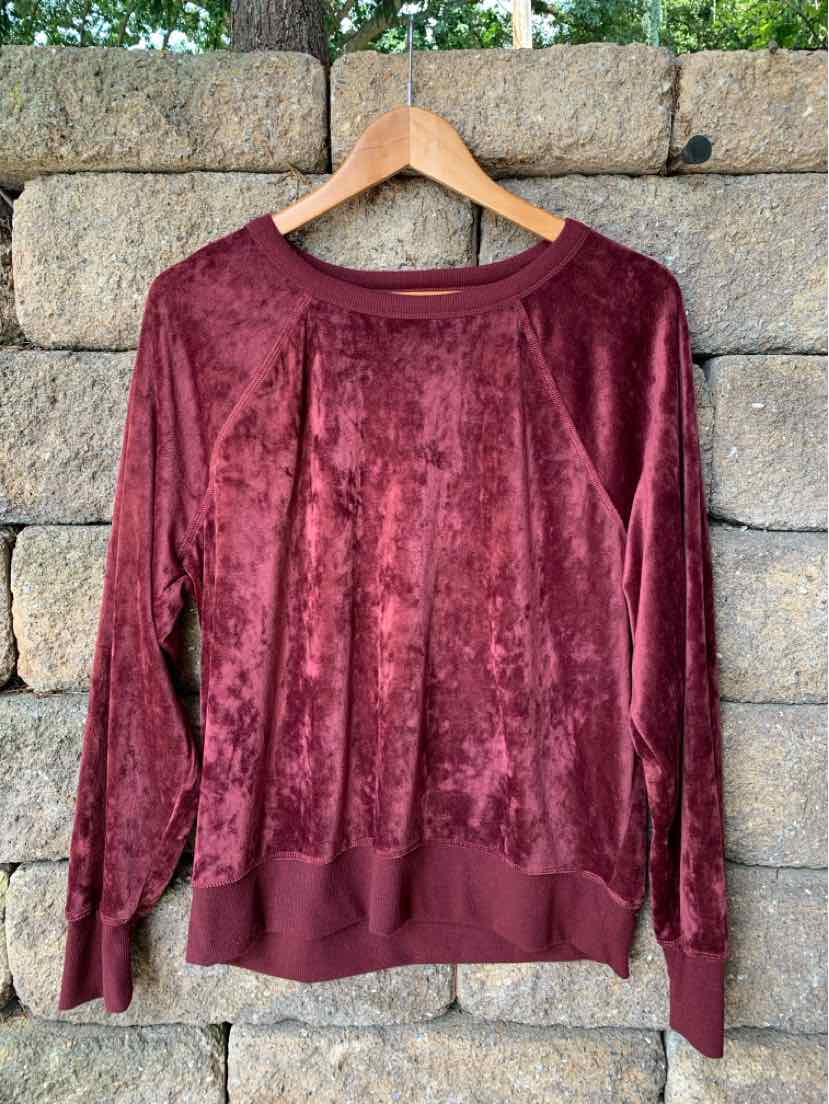 Burgundy long-sleeve velour pullover with ribbed cuffs and hem on wooden hanger.