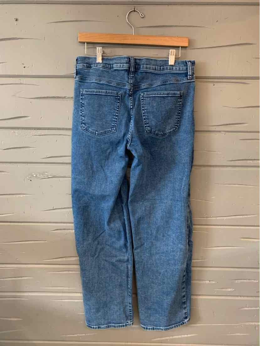 Blue denim jeans with a straight leg cut, back pockets, and belt loops hanging on a wooden hanger.