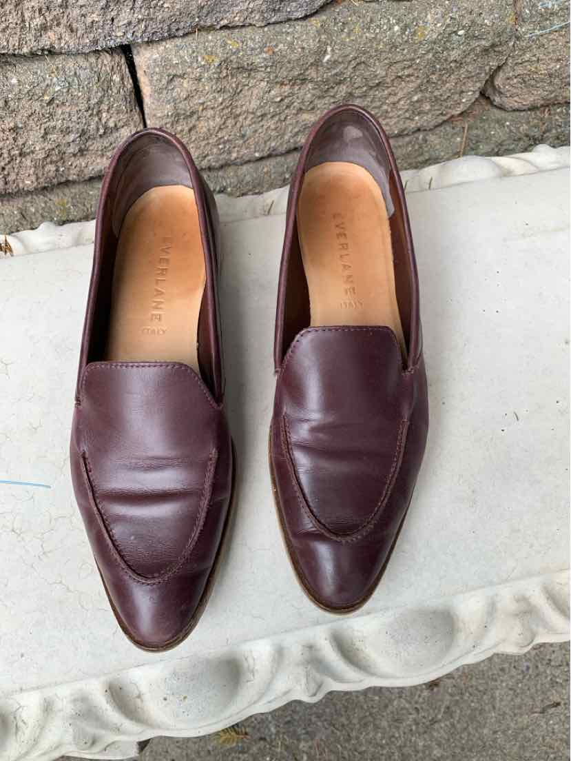 Pair of dark brown leather slip-on loafers with rounded square toes and smooth finish.