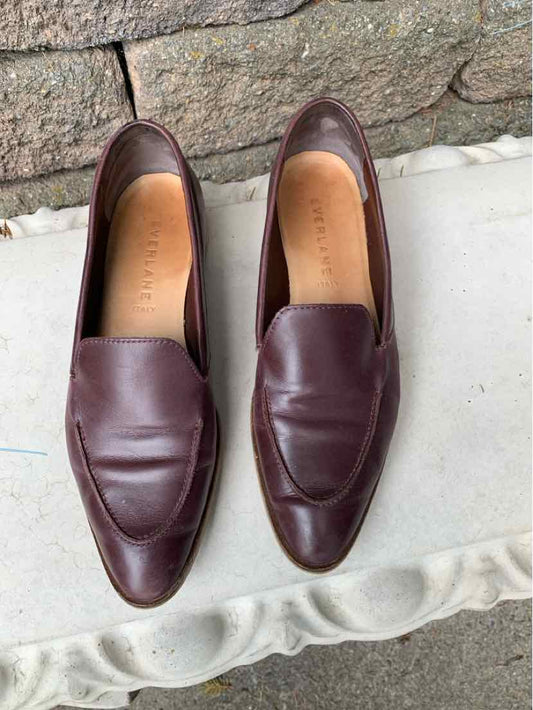 Pair of dark brown leather slip-on loafers with rounded square toes and smooth finish.