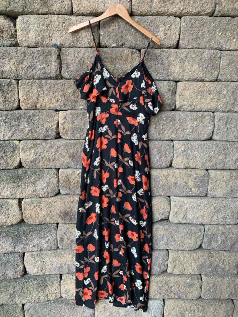Black floral midi dress with orange and white flowers, thin adjustable straps, and ruffle neckline.