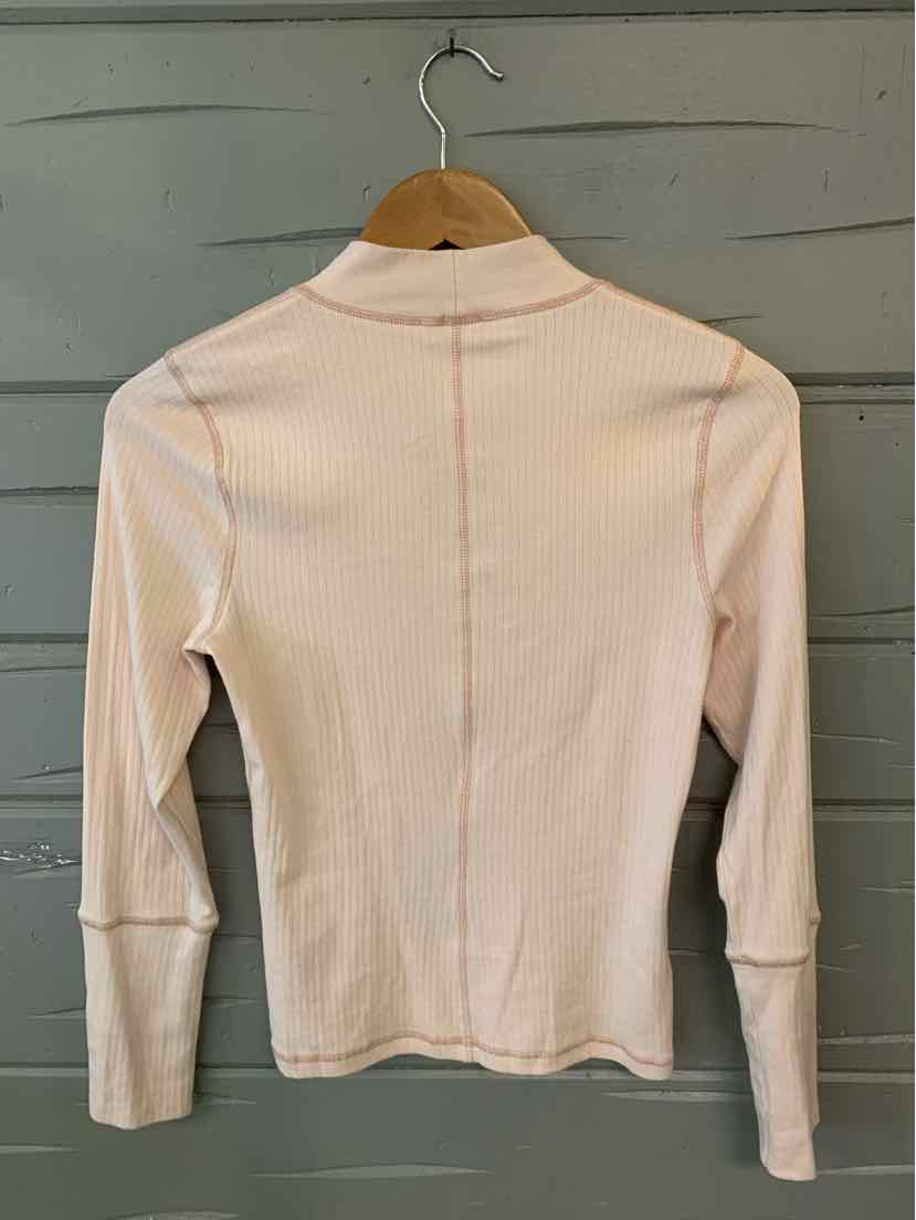 Light pink ribbed long-sleeve top with mock neck and seam detail down the back.