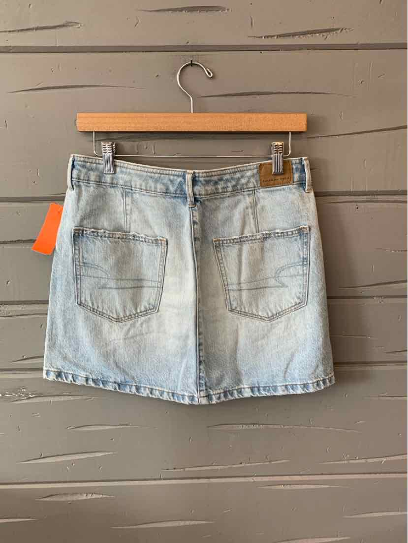 Light blue denim mini skirt with front button and zipper closure, two front pockets, and belt loops.