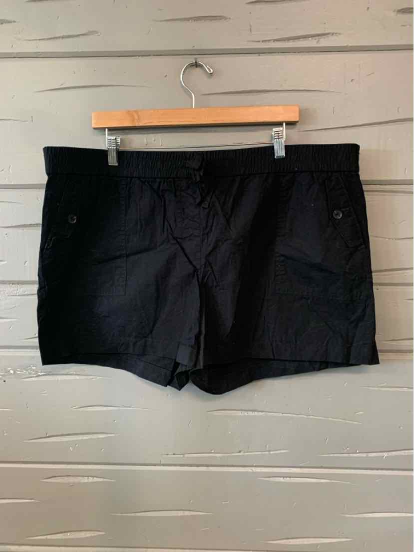 Black women's lightweight shorts in size XL with buttoned side pockets hanging on wooden hanger.