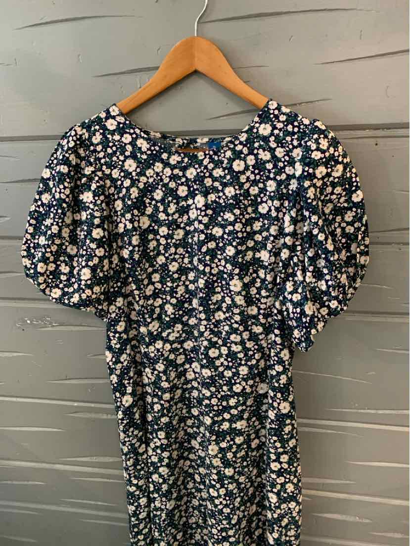 Navy blue floral dress with puff sleeves and gathered waist on wooden hanger.