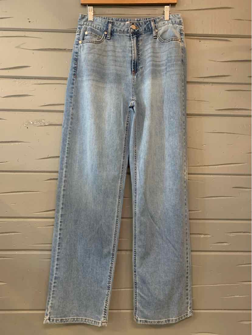 Light-wash blue straight-leg jeans with a faded finish, hanging from a wooden clip hanger.