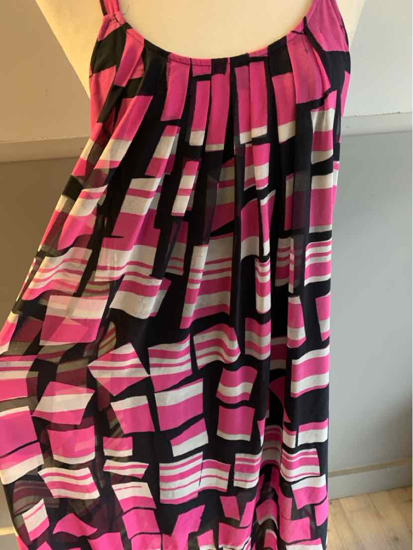 Pink, black, and white color-block sleeveless dress with pleated bodice and flowing skirt.