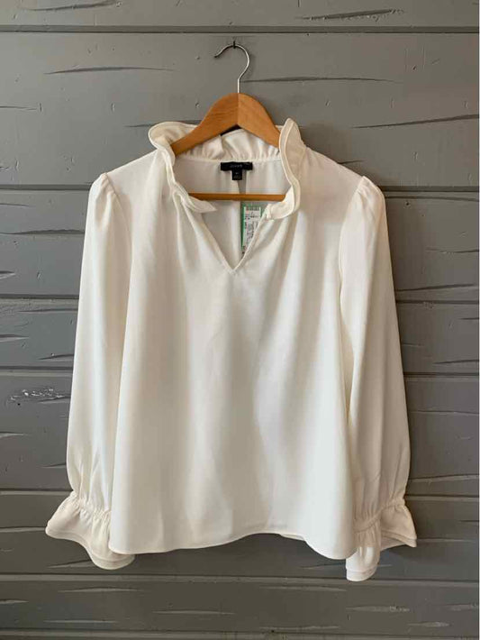 White long-sleeve blouse with ruffled collar and cuffs, relaxed fit, keyhole neckline.