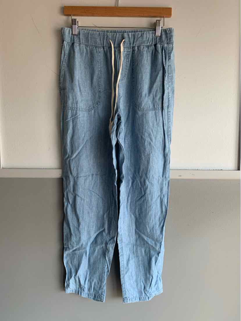 Light blue casual pants with elastic waistband and white drawstring hanging on wooden hanger.