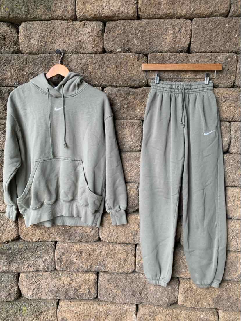 Light gray Nike hoodie and sweatpants set with white swoosh logos, soft cotton fabric, relaxed fit.