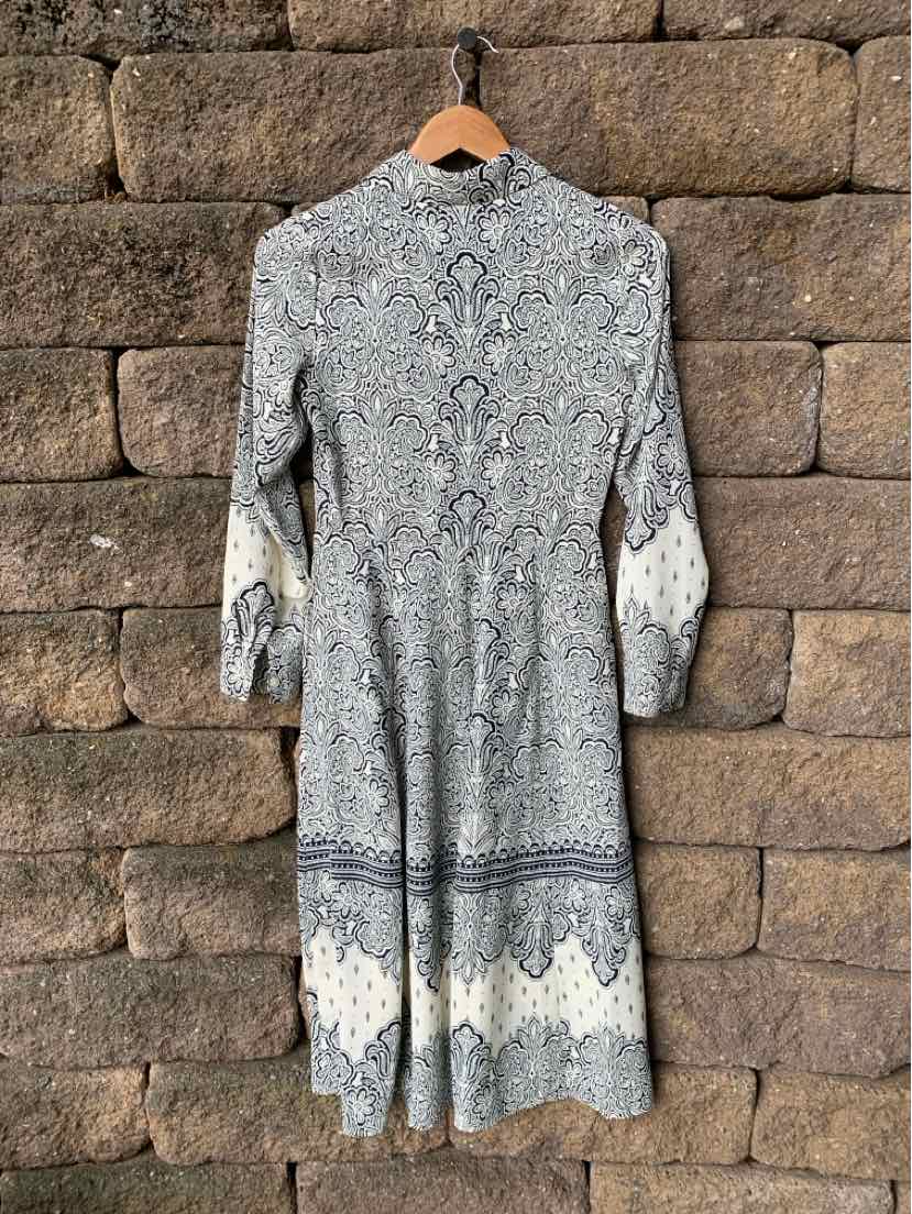 Long-sleeve knee-length dress with intricate gray and white paisley pattern on lightweight fabric.