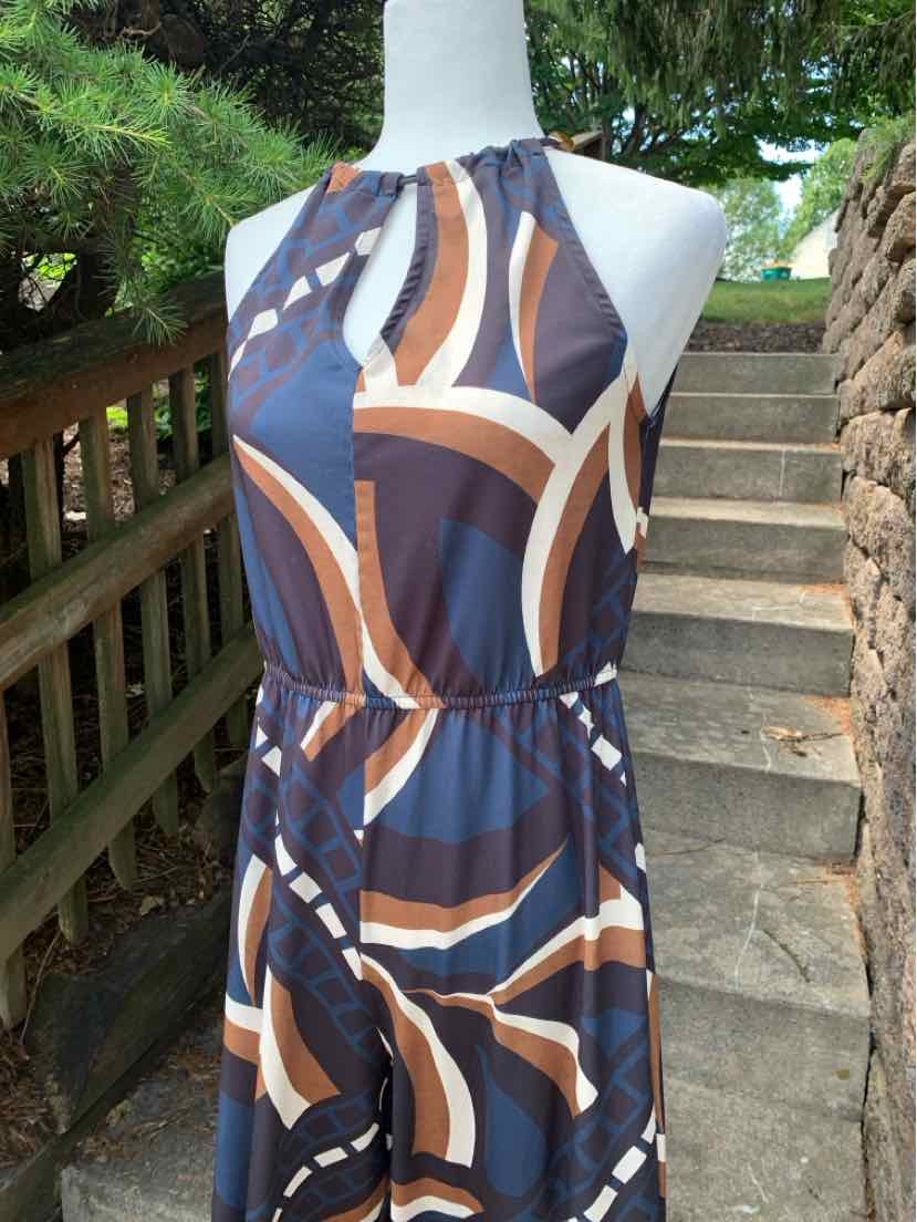 Sleeveless midi dress with navy, brown, and cream abstract geometric print and cinched waist.