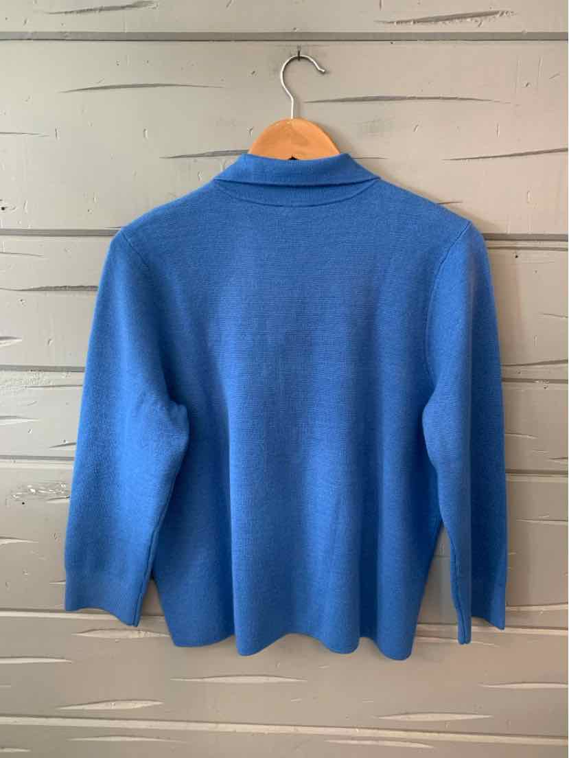 Blue long-sleeve knit sweater with a shawl collar hanging on wooden hanger.