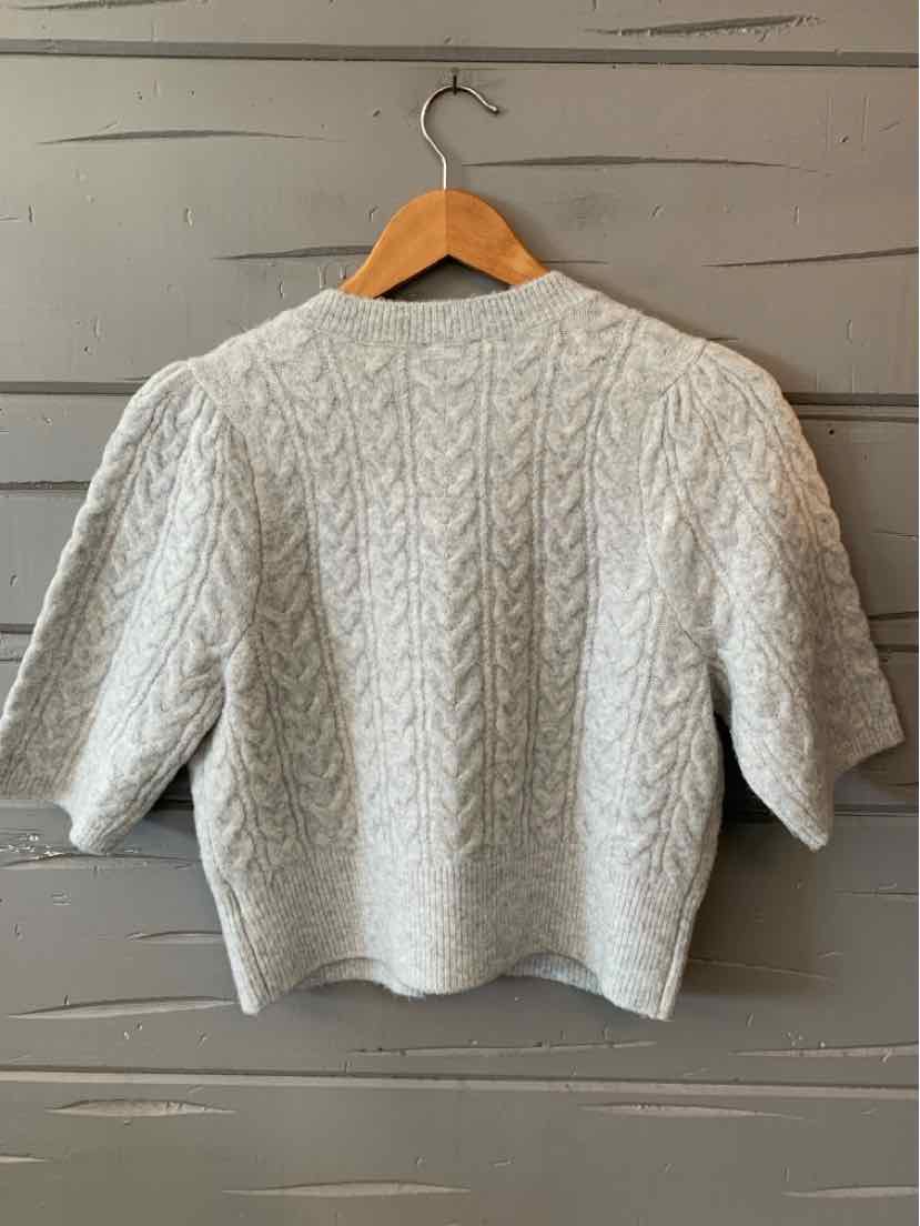 Light gray cable knit short-sleeve sweater with a boxy fit on wooden hanger.