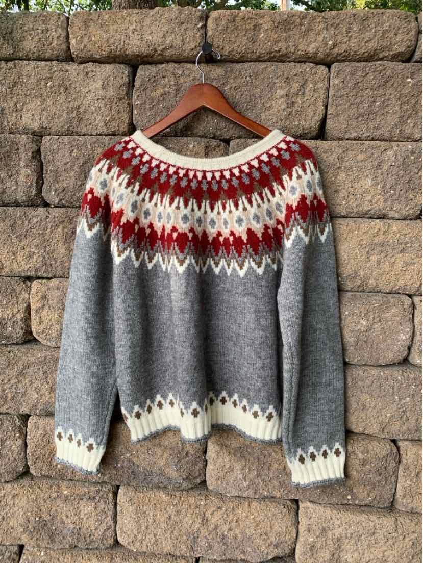 Gray Fair Isle knit sweater with a red, white, and cream yoke, patterned cuffs, and hem.