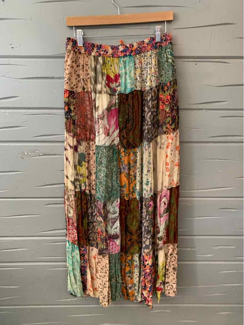 Long patchwork skirt with multicolored floral and solid fabric panels in earthy tones.