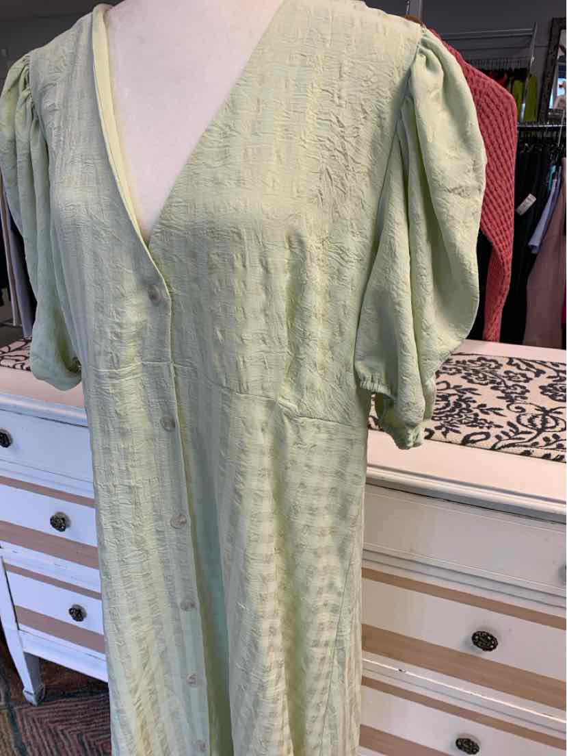 Light green dress with puff sleeves and V-neckline on mannequin.