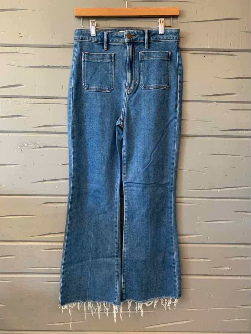 Blue denim jeans with front patch pockets and frayed hem, casual women's style.