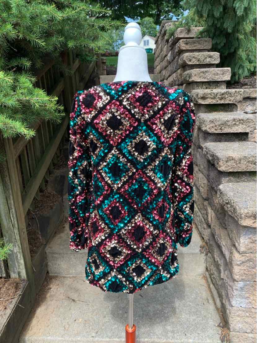 Long-sleeve top with multicolored sequin diamond pattern in teal, pink, black, and gold.