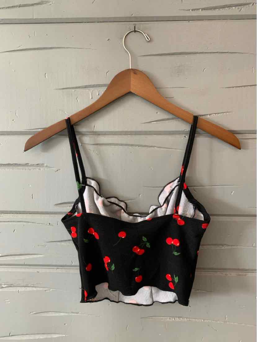 Black cropped camisole with red cherry print, adjustable thin straps, and scalloped white lining edges.