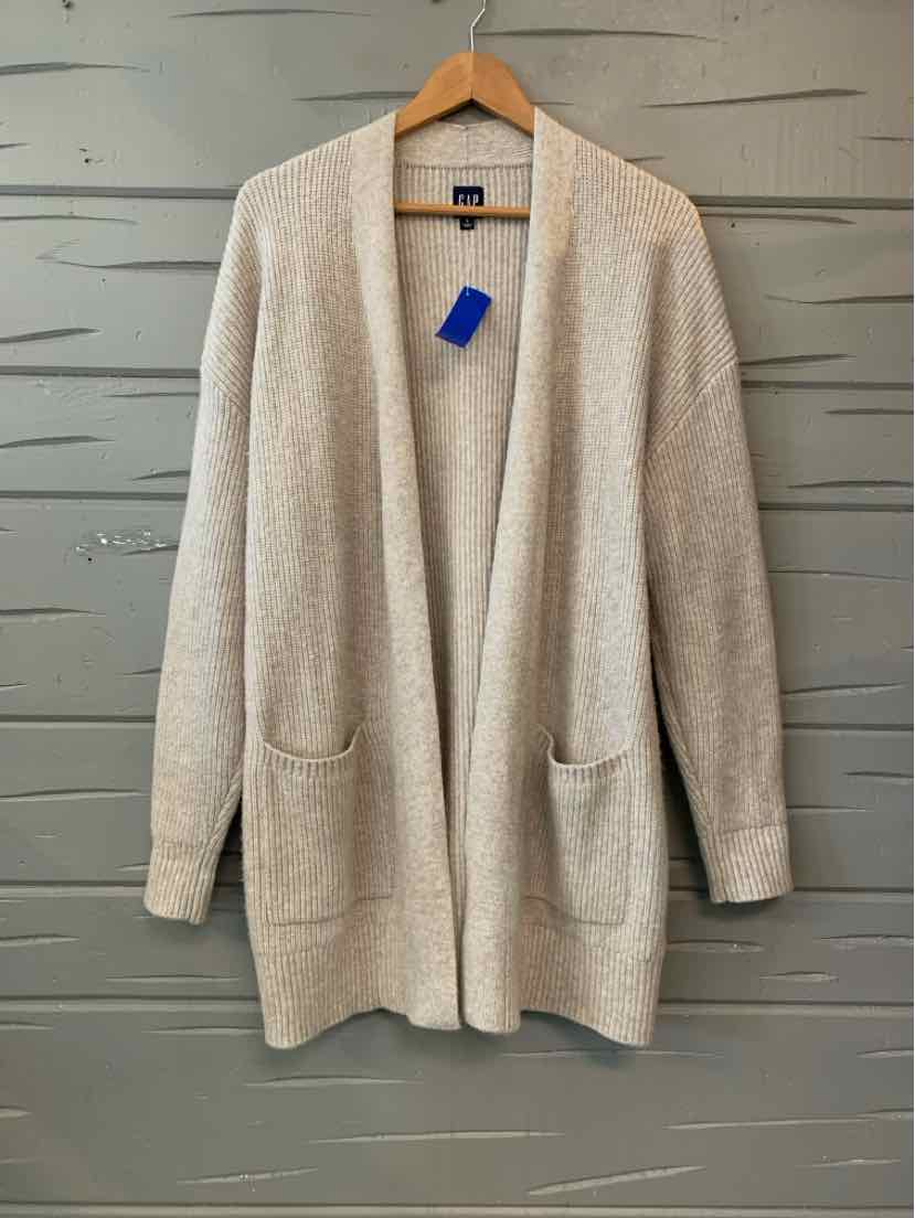 Beige knit GAP cardigan with an open front, long sleeves, and two patch pockets.